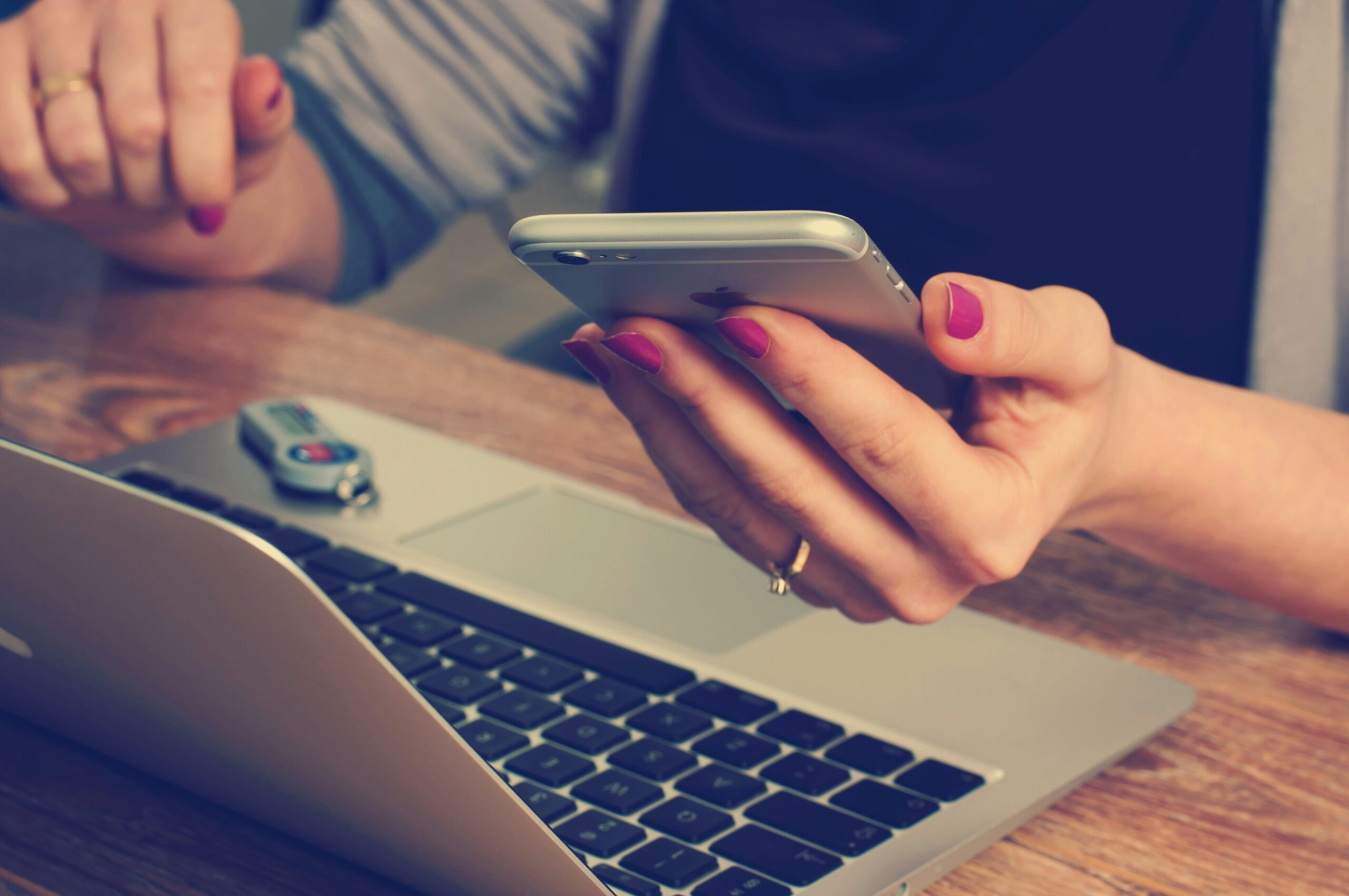A professional using a smartphone and laptop to track engagement measurement strategies. - Nurture Machines A professional using a smartphone and laptop to track engagement measurement strategies.