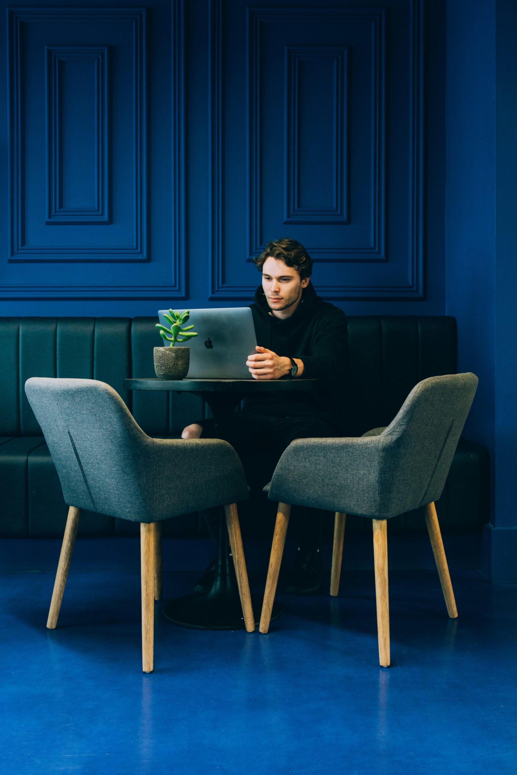 Professional man analyzing lead nurturing data on a laptop in a modern office - Nurture Machines A person in a modern café, sitting at a table with a laptop, working on identifying key techniques for effective lead scoring automation.