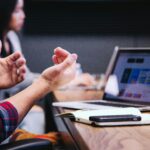 A team collaborates around a laptop displaying a website layout, highlighting the importance of trust signals to quickly boost user confidence and engagement.