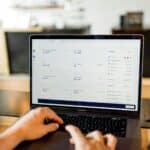 A person analyzes detailed marketing metrics on a laptop dashboard, demonstrating how attribution modeling enhances accuracy in customer acquisition ROI measurement.
