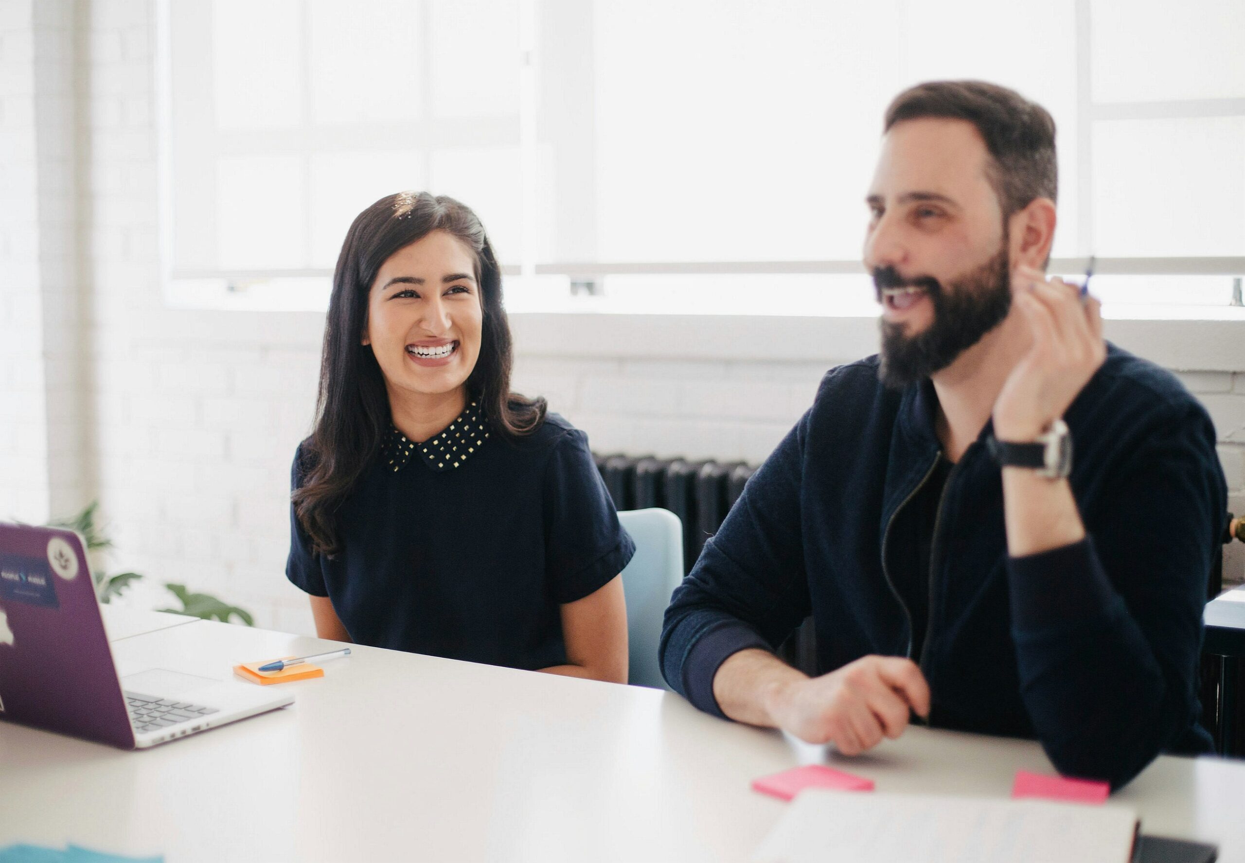 A woman and a man in a meeting room can be seen smiling - Nurture Machines A woman and a man in a meeting room can be seen smiling