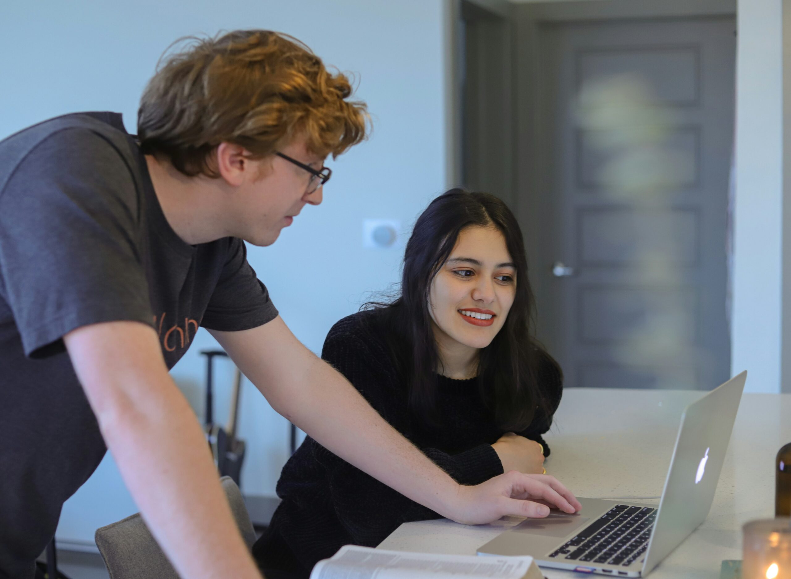 A man discussing the advantages of lead nurturing automation with a woman while viewing a laptop screen. - Nurture Machines A man discussing the advantages of lead nurturing automation with a woman while viewing a laptop screen.