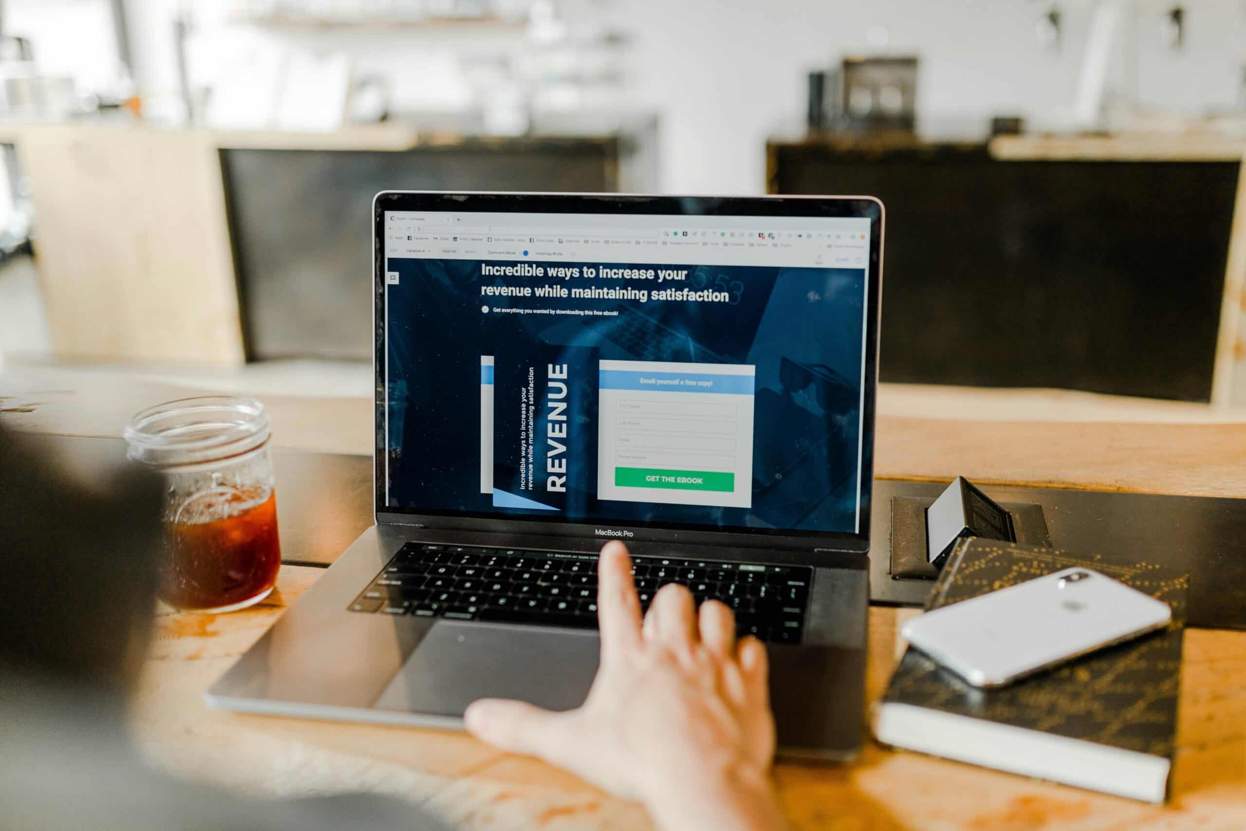 A person browsing a lead generation landing page offering a revenue-focused ebook to attract qualified prospects. - Nurture Machines A person browsing a lead generation landing page offering a revenue-focused ebook to attract qualified prospects.