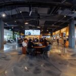 a bustling modern office environment showcases a collaborative team brainstorming session, with vibrant visuals of engaged employees discussing strategies on large digital screens, highlighting the theme of enhancing customer experience for loyalty.