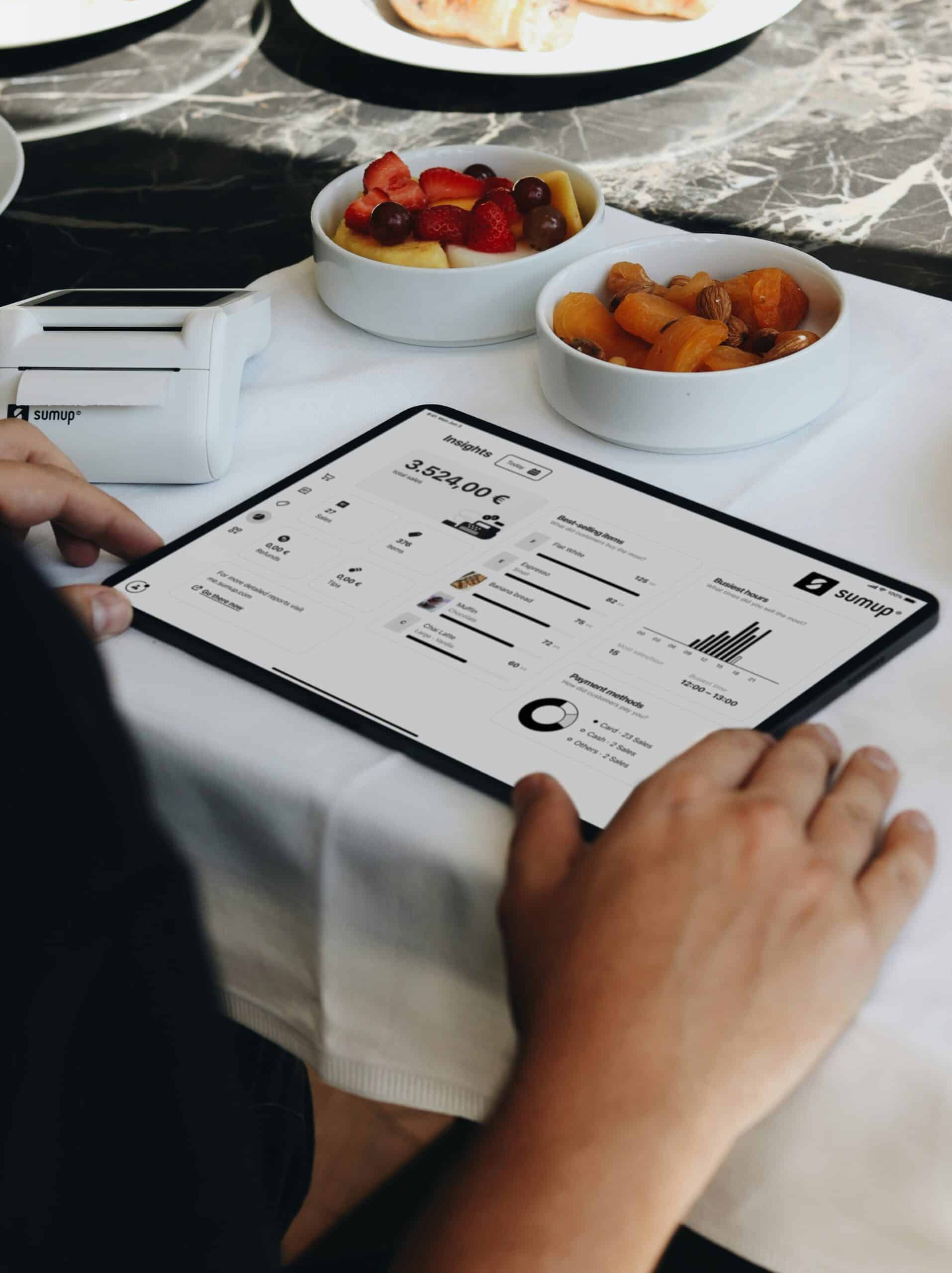 Business owner reviews SumUp analytics dashboard on a tablet to track sales funnel metrics using top-tier sales funnel analytics software tools. - Nurture Machines Business owner reviews SumUp analytics dashboard on a tablet to track sales funnel metrics using top-tier sales funnel analytics software tools.