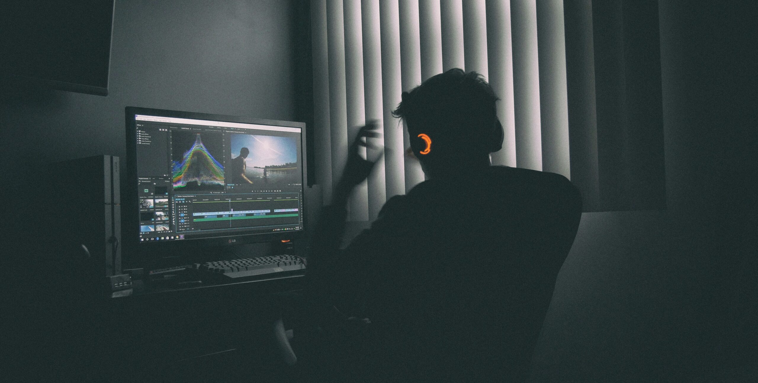 A person edits video content in a dimly lit room, emphasizing the role of creative storytelling in crafting compelling content that drives landing page conversions.