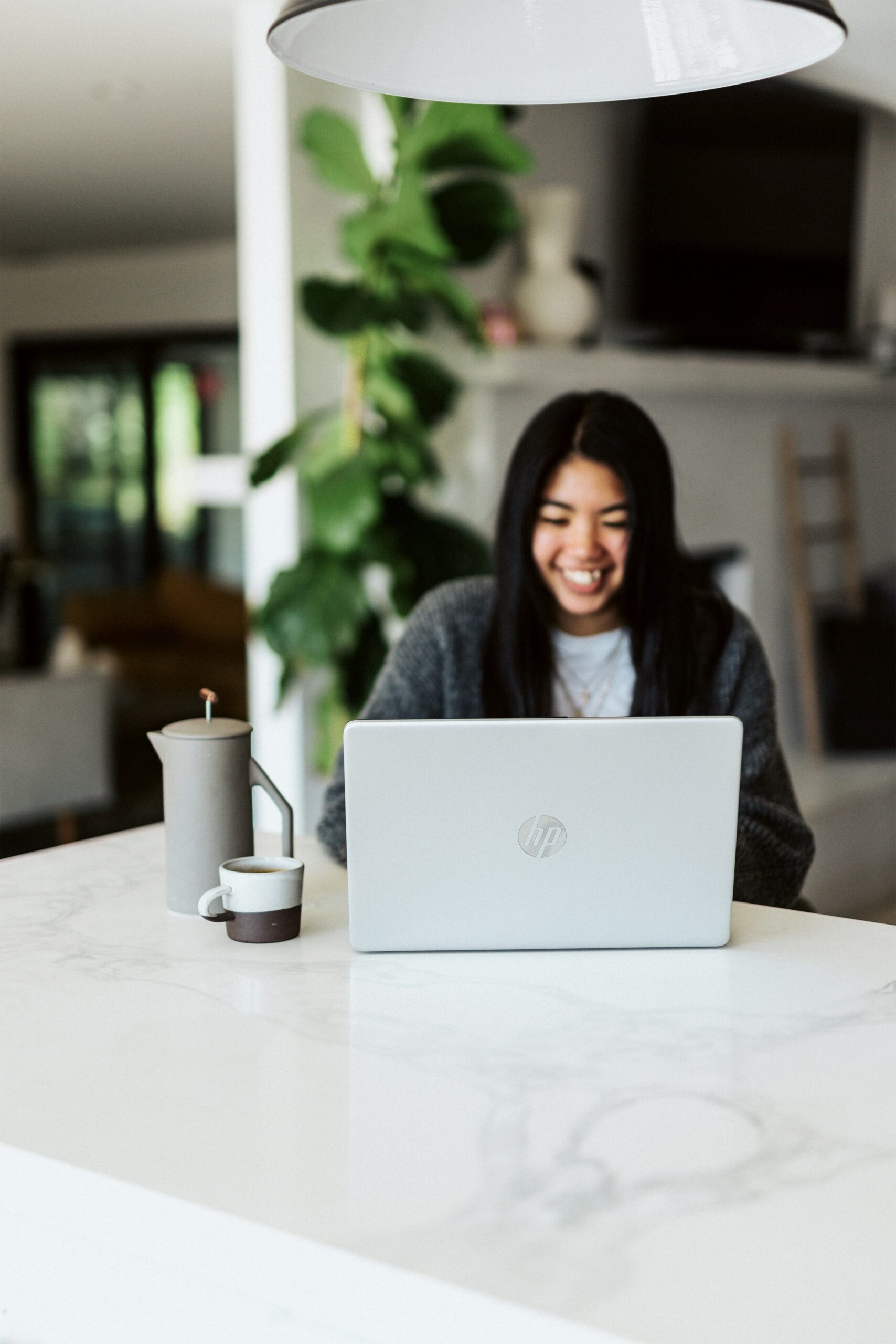 A smiling woman working on a laptop at home, symbolizing the power of strategic partnerships and virtual collaboration for shared customer acquisition. - Nurture Machines A smiling woman working on a laptop at home, symbolizing the power of strategic partnerships and virtual collaboration for shared customer acquisition.