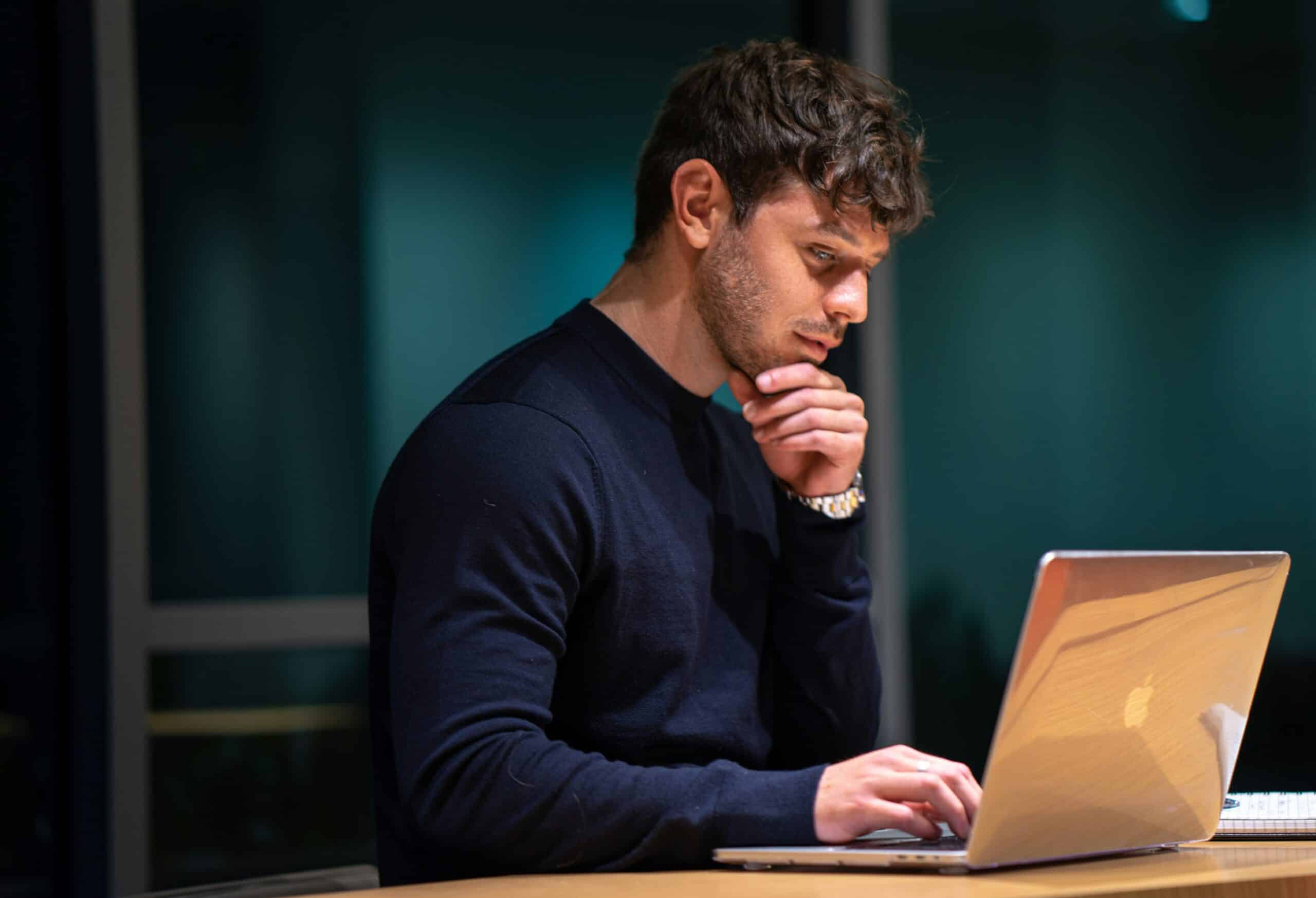 A focused professional researching on a laptop, exploring the most effective customer acquisition channels for business growth.