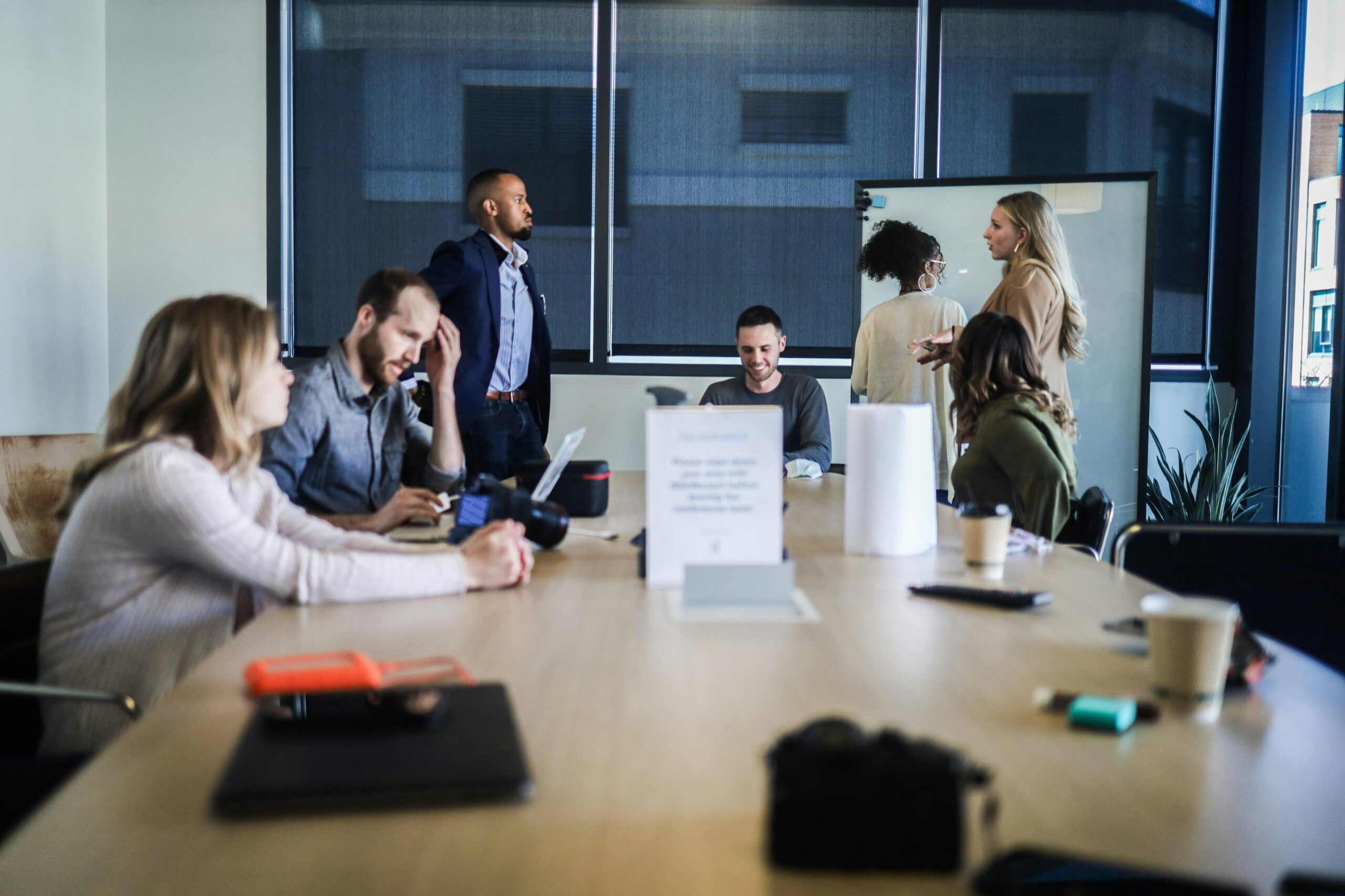 A diverse team collaborates in a modern meeting room, reflecting low-budget strategies to boost brand awareness and reach during the customer journey's early stage.