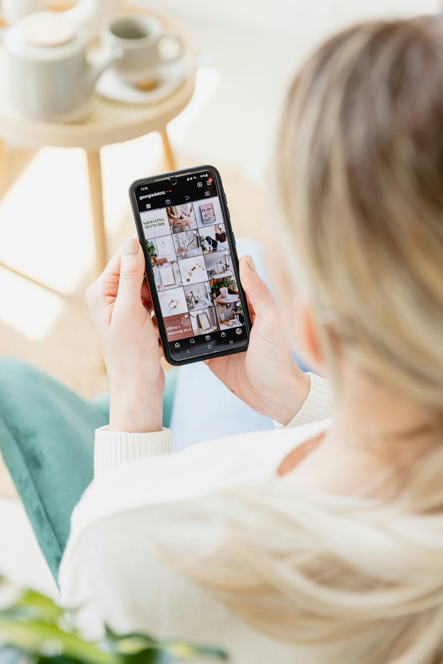 A woman browsing a visually curated Instagram feed, representing the strategic use of micro-influencers to foster authentic audience connections and boost brand reach. - Nurture Machines A woman browsing a visually curated Instagram feed, representing the strategic use of micro-influencers to foster authentic audience connections and boost brand reach.