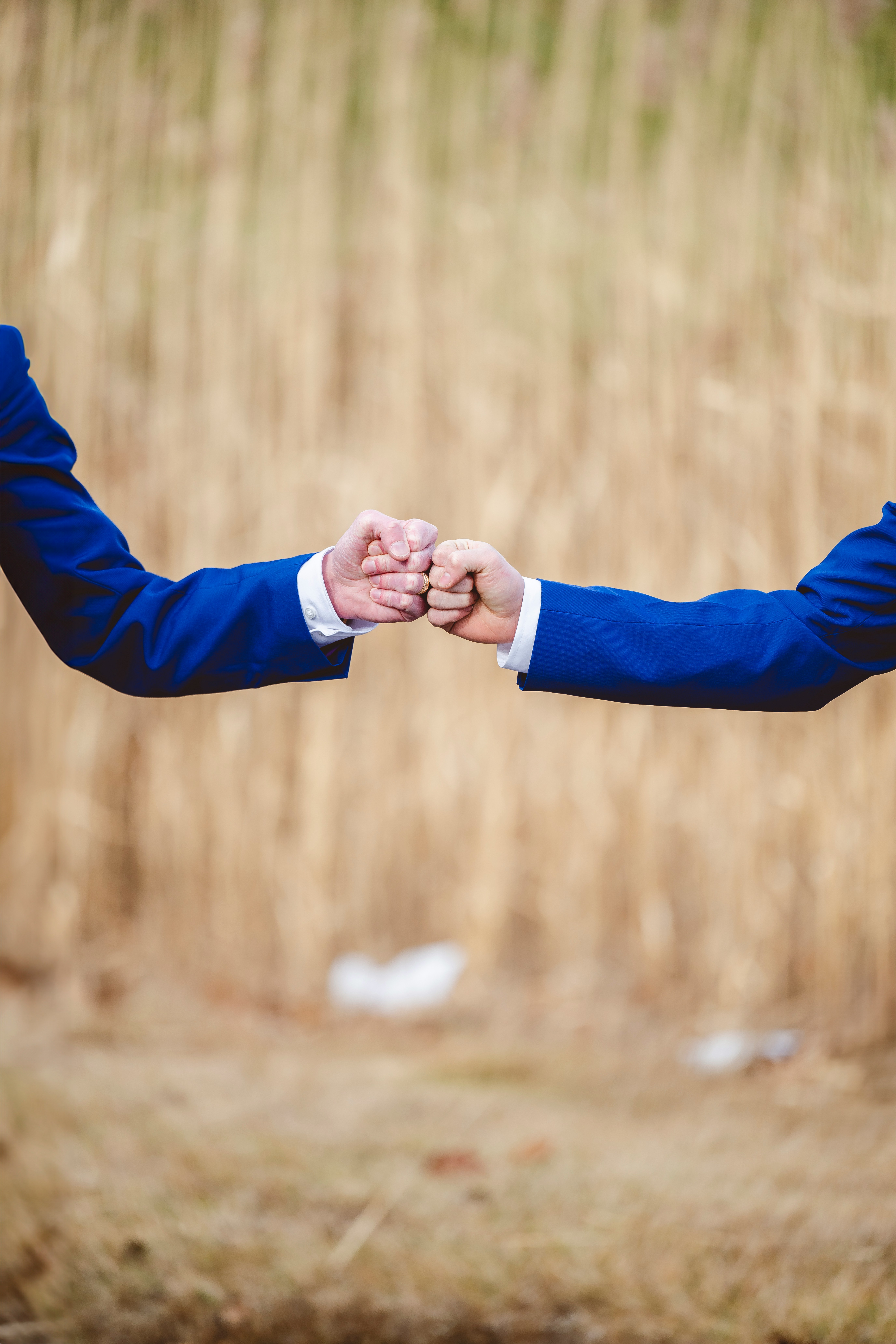 Two people in matching blue suits share a fist bump, symbolizing trust and mutual commitment—key elements in customizing strategies for long-term customer loyalty. - Nurture Machines Two people in matching blue suits share a fist bump, symbolizing trust and mutual commitment—key elements in customizing strategies for long-term customer loyalty.