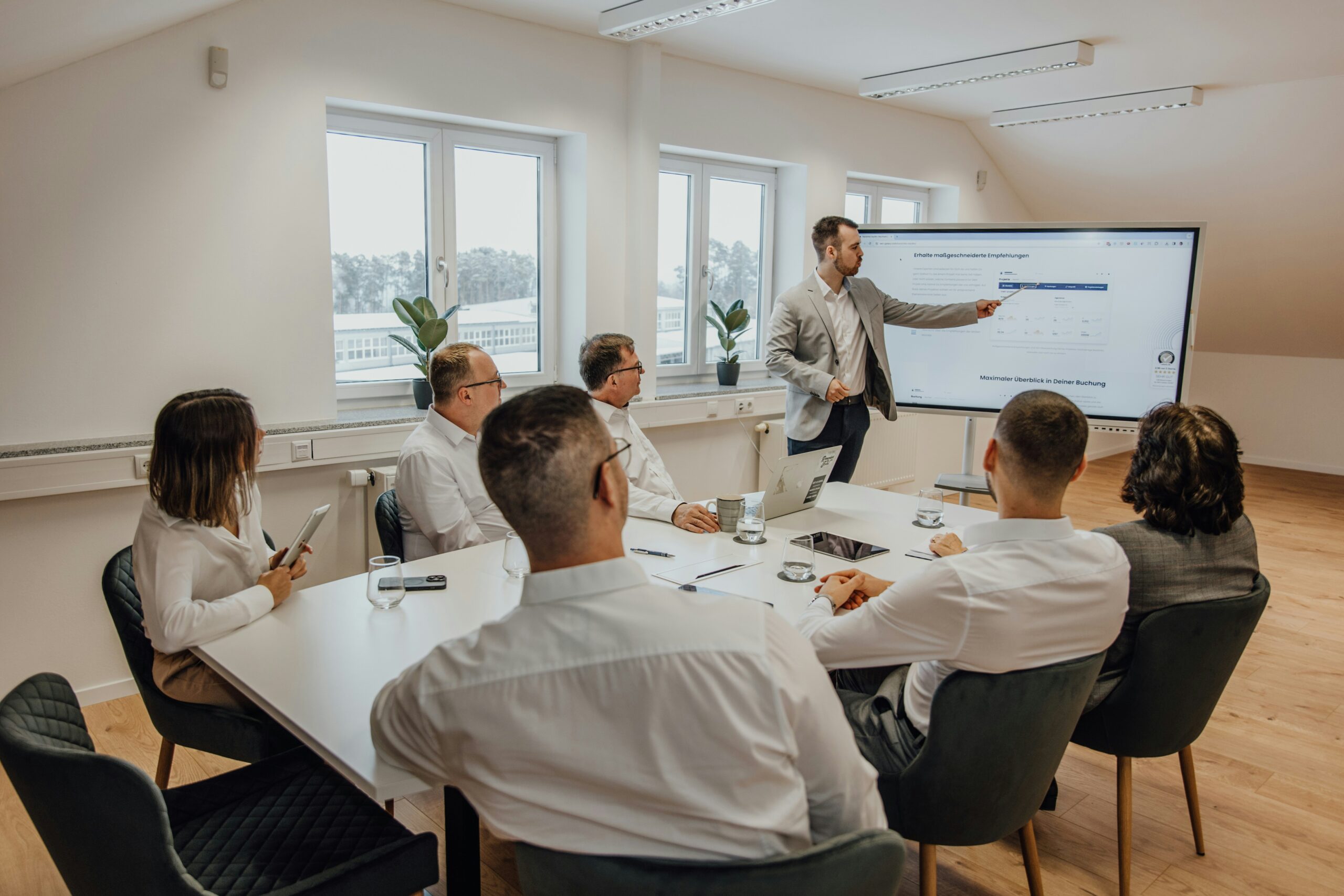 A professional presents retention software features to a team during a meeting, illustrating how automation tools can streamline and scale customer retention efforts. - Nurture Machines A professional presents retention software features to a team during a meeting, illustrating how automation tools can streamline and scale customer retention efforts.