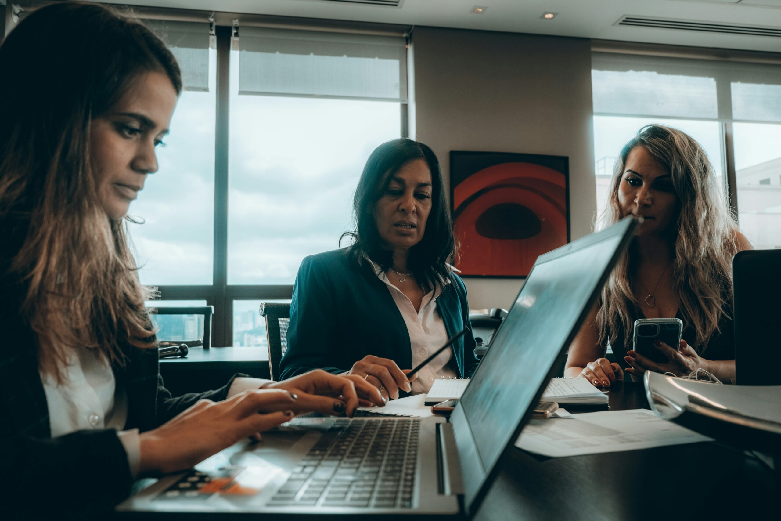 Three professionals collaborating over digital tools, illustrating how personalized strategies can build deeper connections with diverse customer groups.