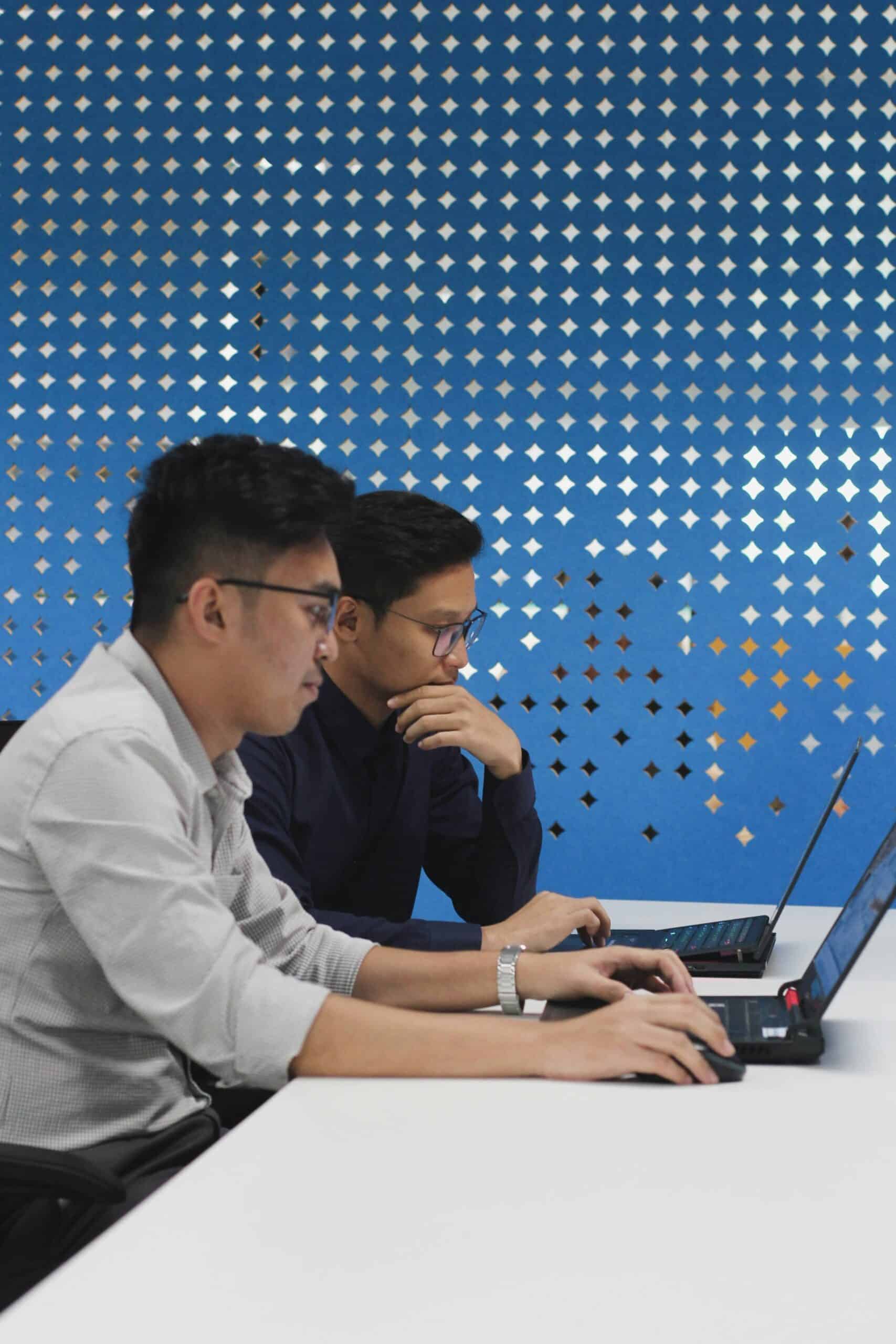Two professionals using laptops, analyzing data to optimize top-of-funnel efficiency with AI-powered lead qualification tools. - Nurture Machines Two professionals using laptops, analyzing data to optimize top-of-funnel efficiency with AI-powered lead qualification tools.