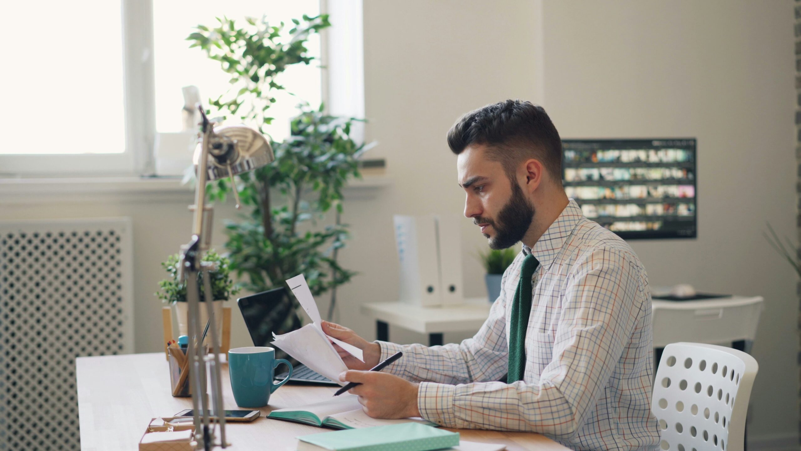 A marketing professional analyzes reports at a desk, identifying which marketing channels to optimize based on current market trends and campaign data.