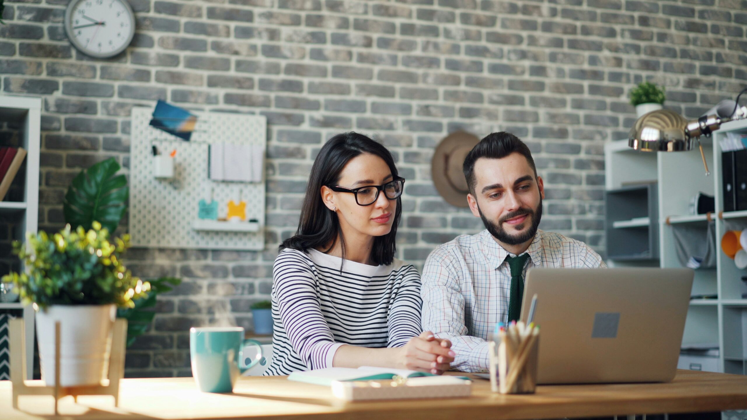 Two professionals attentively watching a laptop during a consulting session focused on improving sales funnel performance.