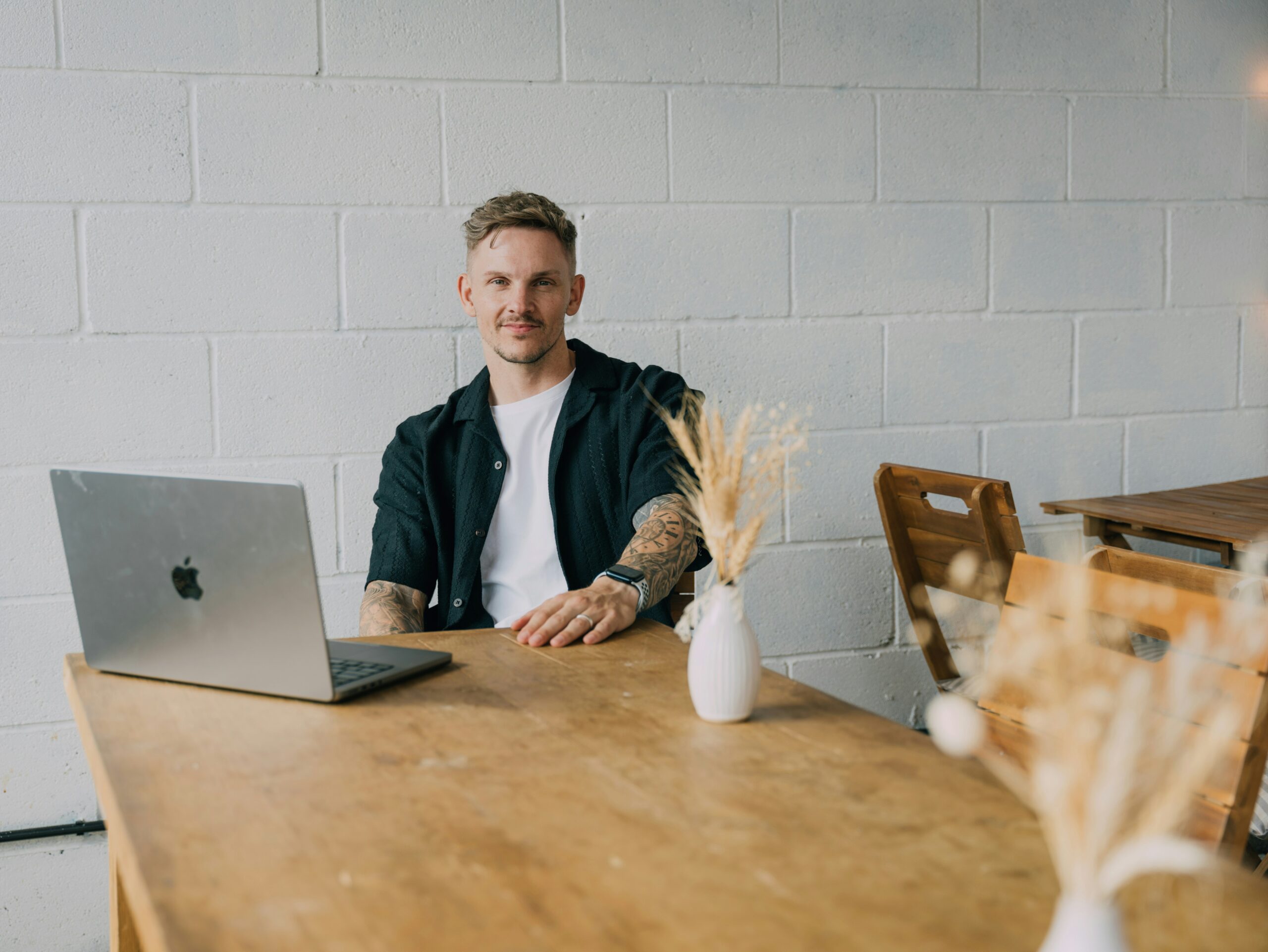 A confident professional sitting beside a laptop in a relaxed setting, representing the importance of customer lifetime value in assessing long-term acquisition success. - Nurture Machines A confident professional sitting beside a laptop in a relaxed setting, representing the importance of customer lifetime value in assessing long-term acquisition success.