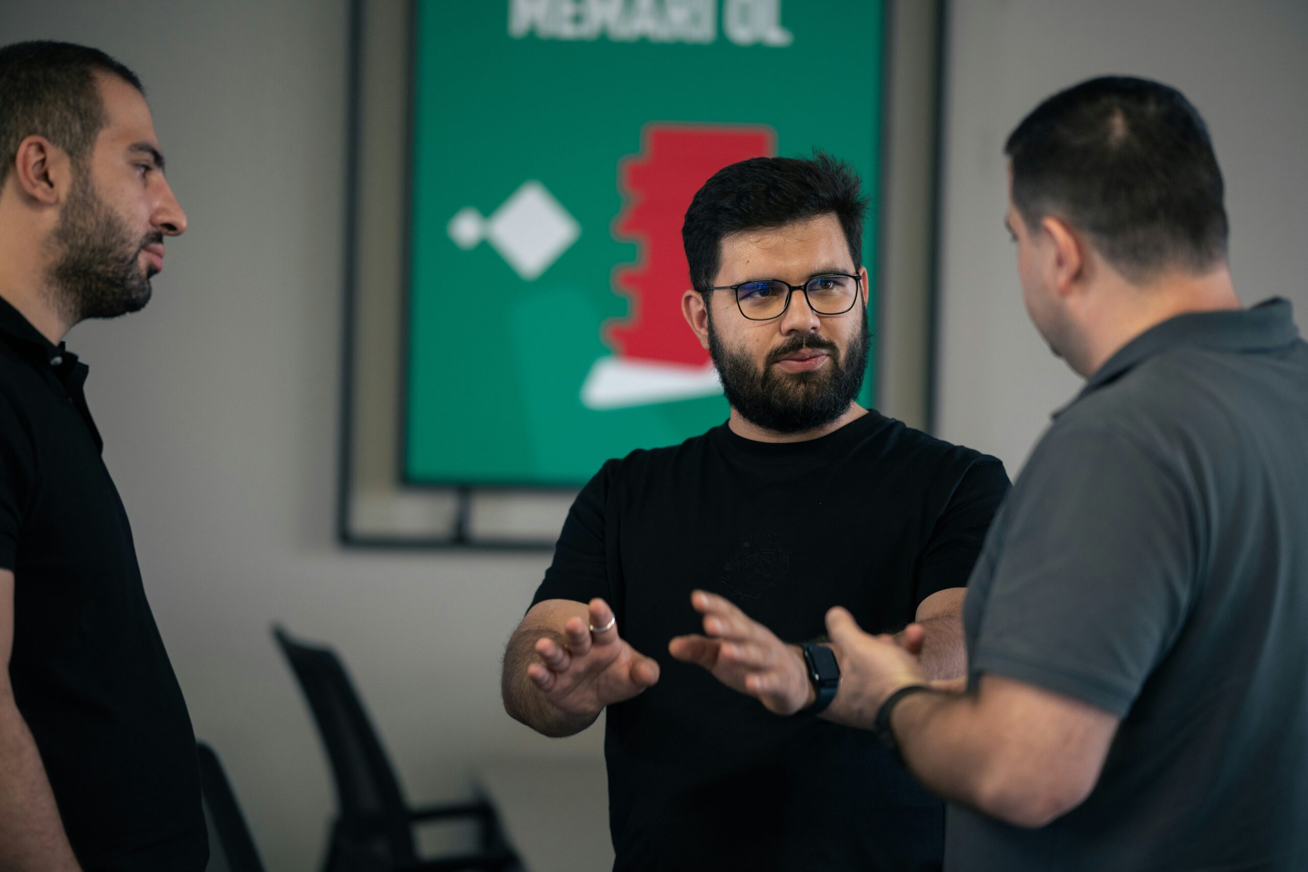 Three men engaged in a serious discussion, reflecting problem-solving around bottom-of-funnel marketing challenges. - Nurture Machines Three men engaged in a serious discussion, reflecting problem-solving around bottom-of-funnel marketing challenges.